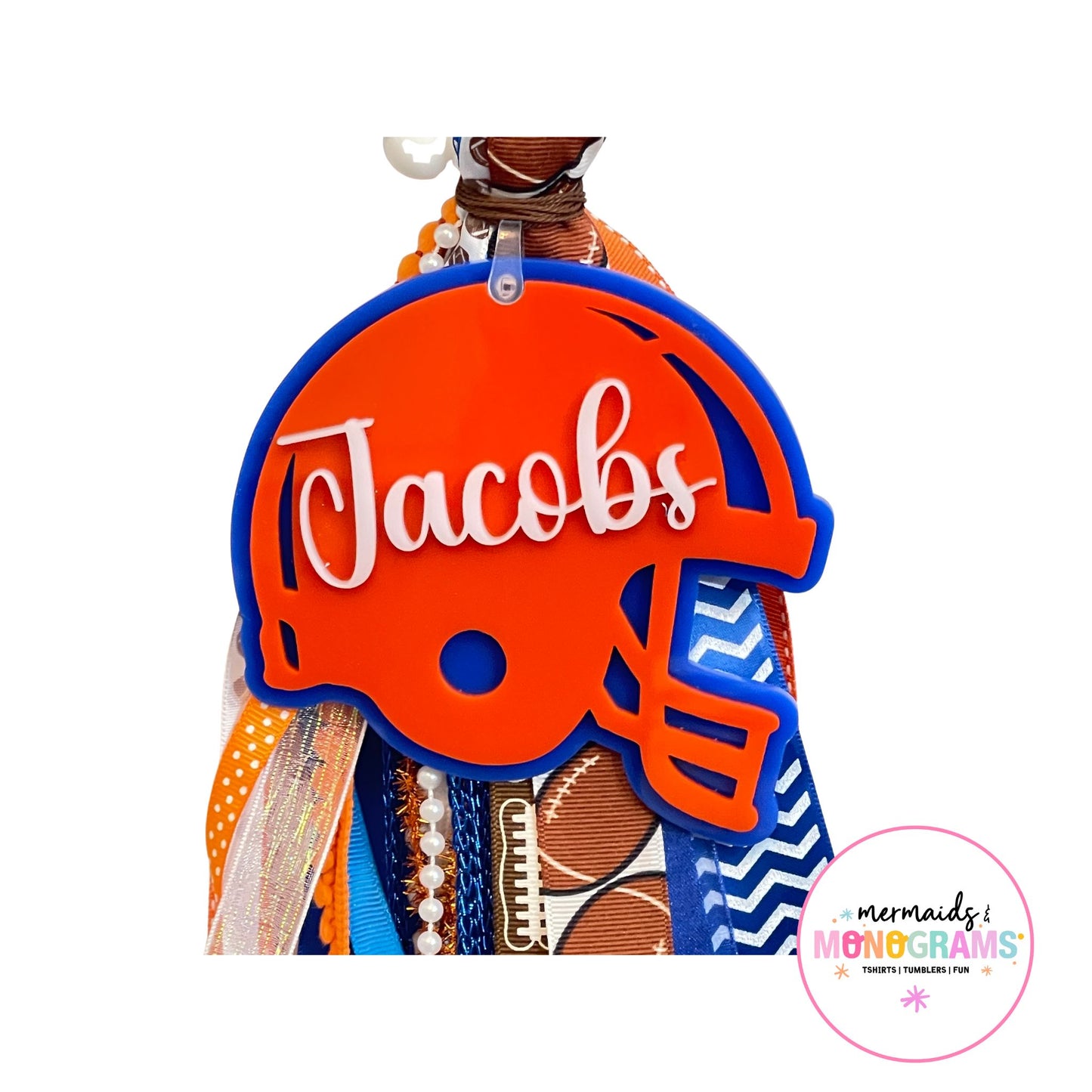 Close-up of personalized acrylic football helmet name tag with โJacobsโ in white script