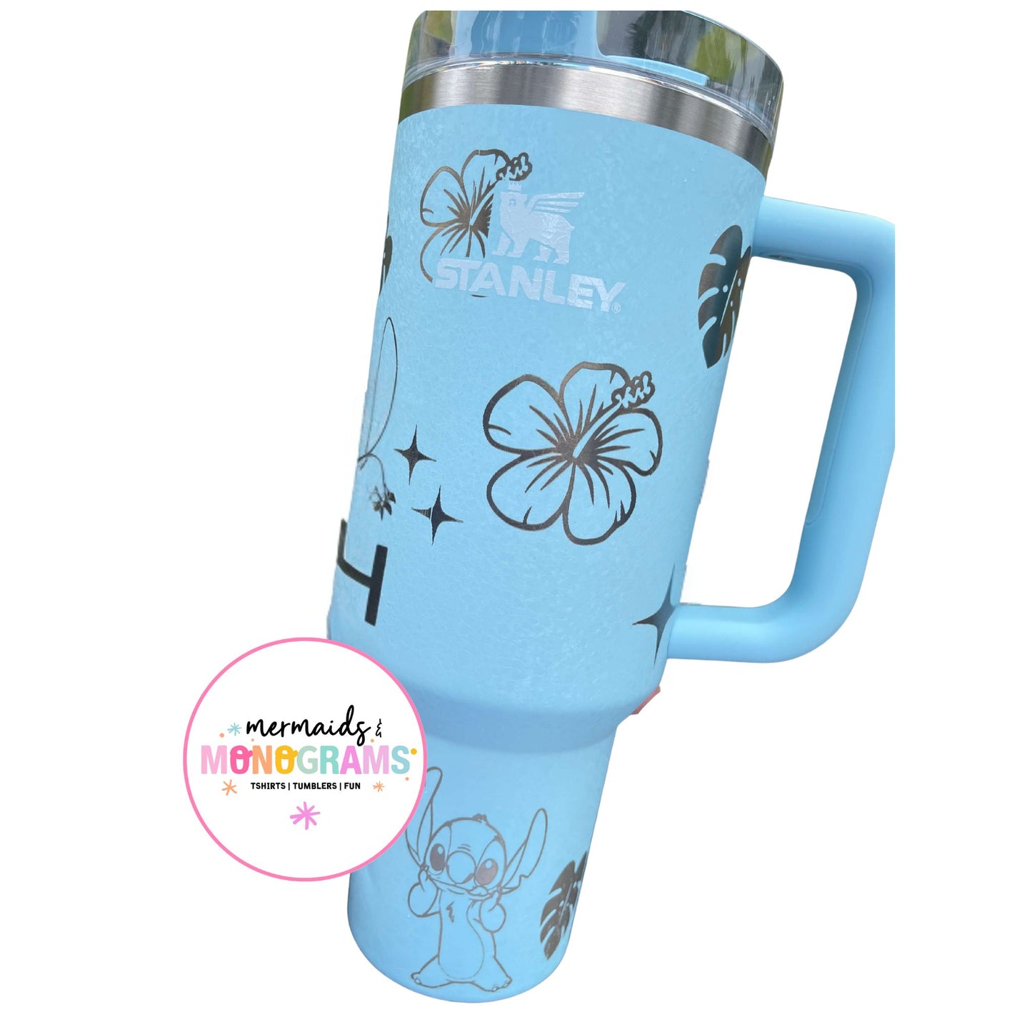 Side view of light blue Stanley tumbler with tropical flower engravings