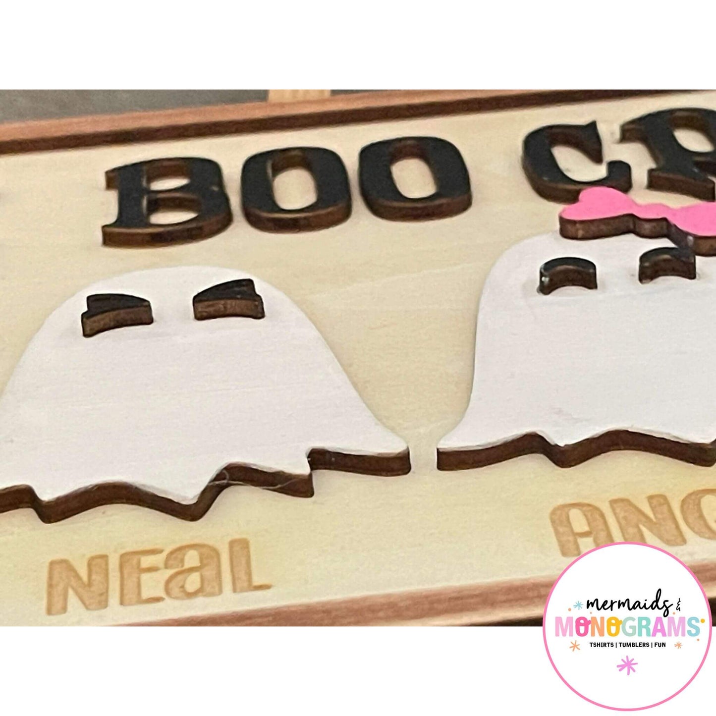 Zoomed-in Halloween Boo Crew sign showing laser engraved ghost characters and individual names like Angela and Neal