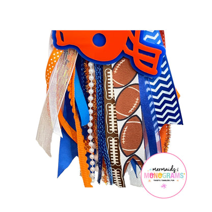 Close-up of football-themed ribbon tassel with pearls, polka dots, glitter, and football prints