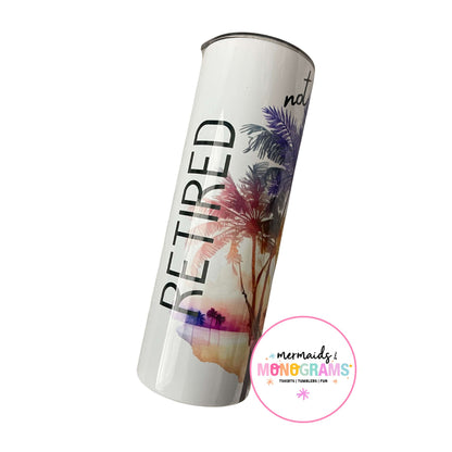 White sublimation tumbler with bold “RETIRED” lettering and palm sunset art