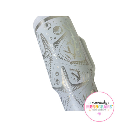 Close-up of silver etched starfish and bubbles on pastel tumbler