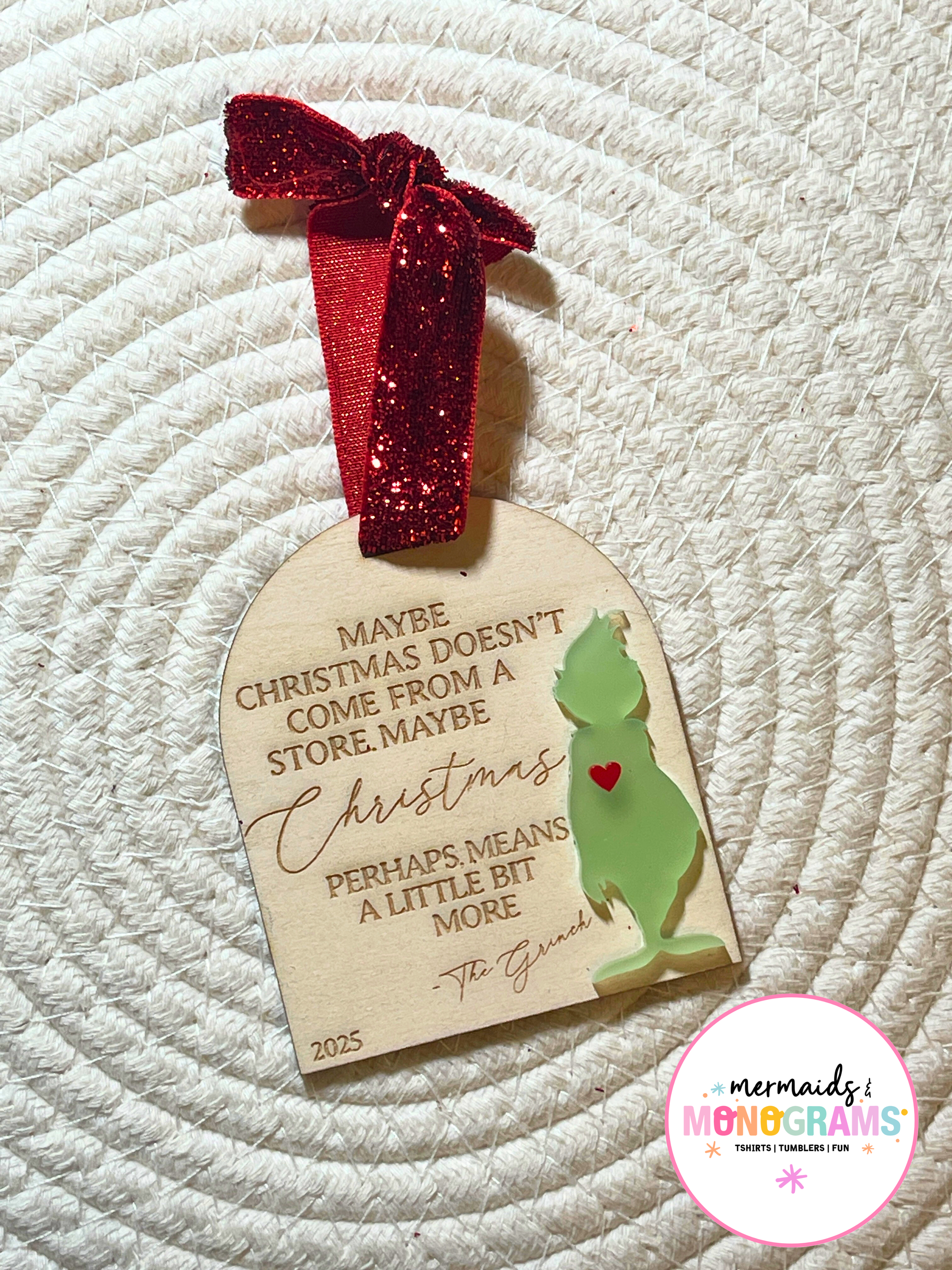 One Grinch-themed wooden Christmas ornament with red glitter ribbon, engraved holiday message, and green acrylic silhouette holding a red heart.