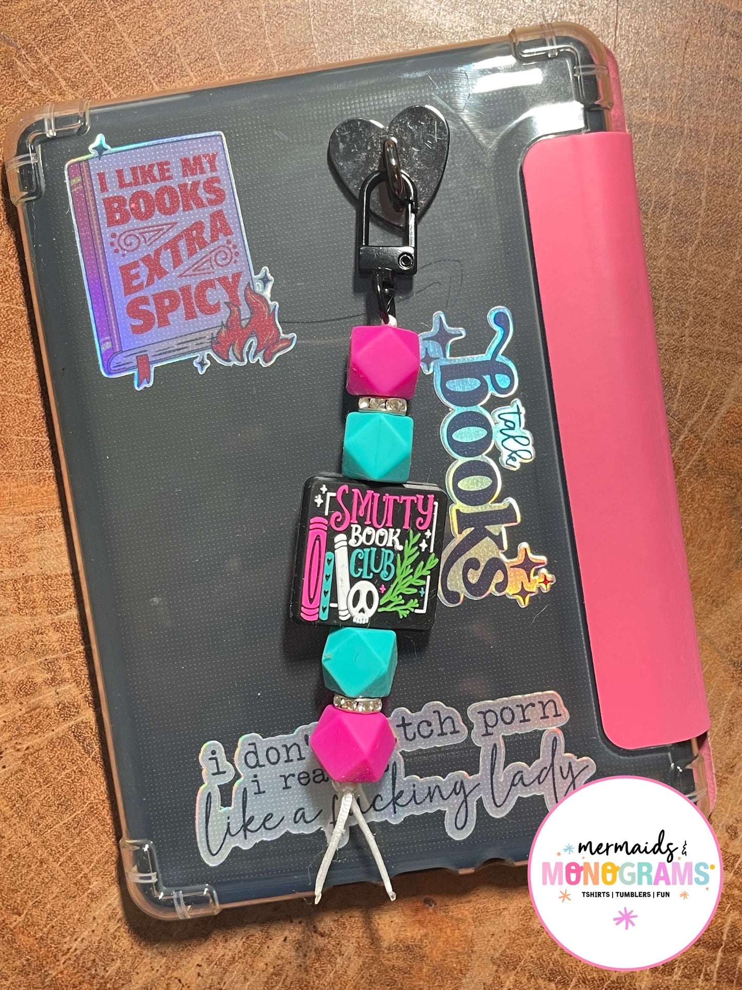 Colorful beaded charm with text on a pink and black background