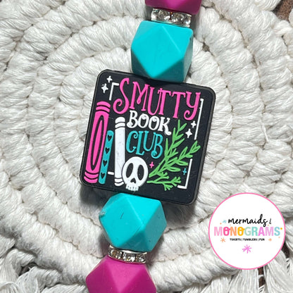 Badge holder with 'Smutty Book Club' design on a textured white background
