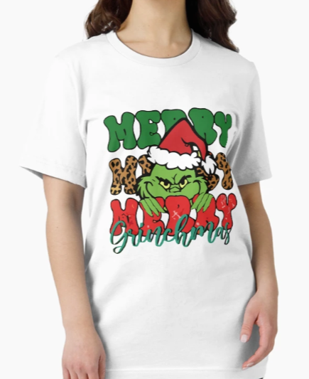 Woman wearing a white t-shirt with a colorful “Merry Merry Merry Grinchmas” design featuring a grumpy Grinch in a Santa hat, bold leopard print, and festive red and green text.