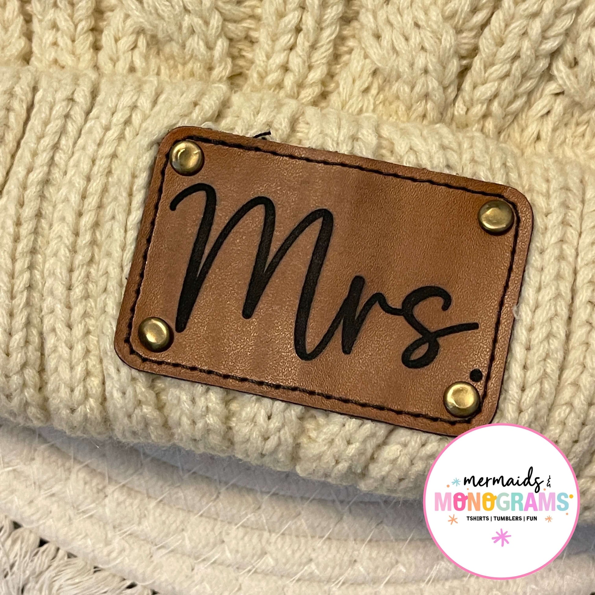 Close-up of engraved leather "Mrs." patch on knit beanie