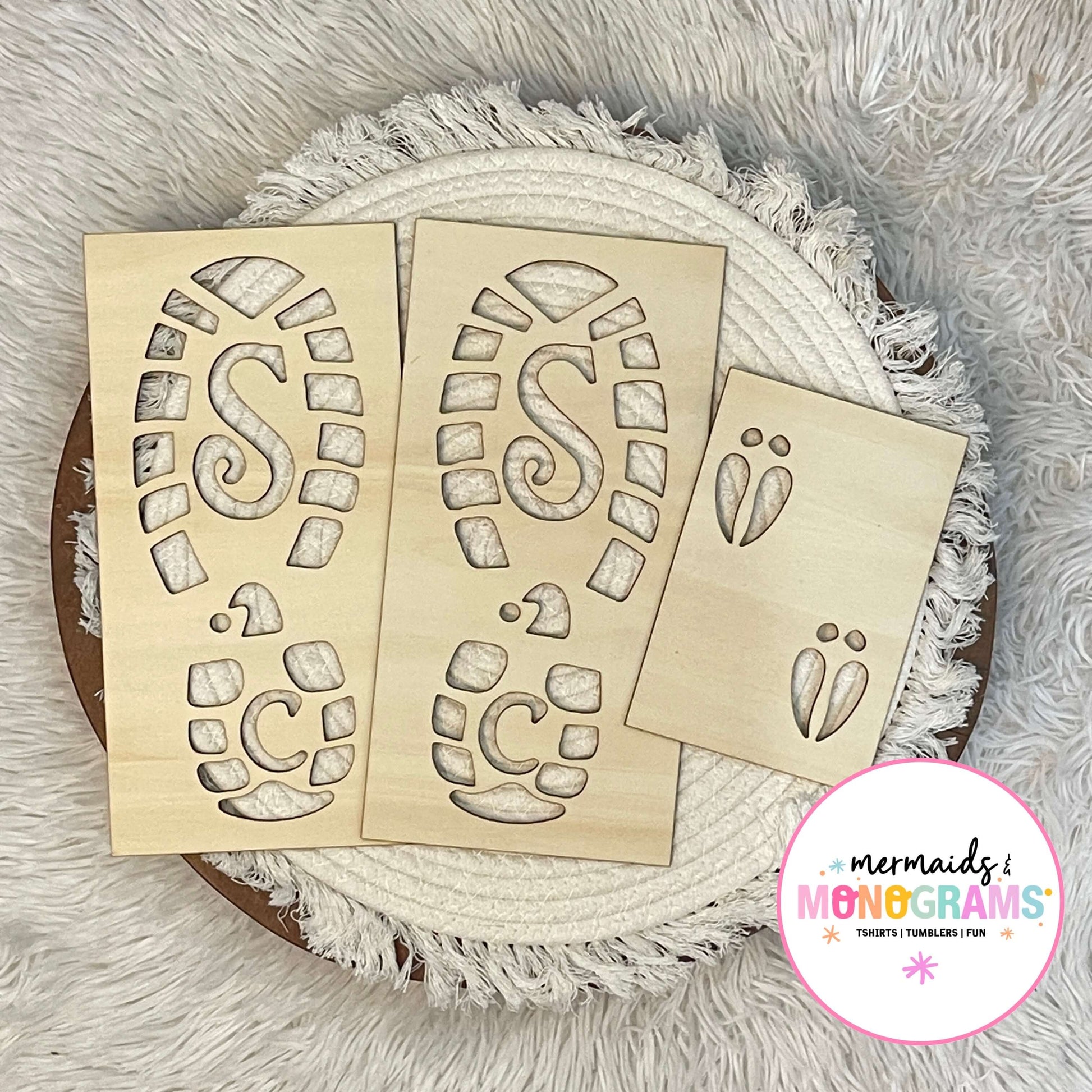 "Wooden Santa boot and reindeer footprint stencils displayed on white textured fabric – perfect for creating magical Christmas morning trails."
