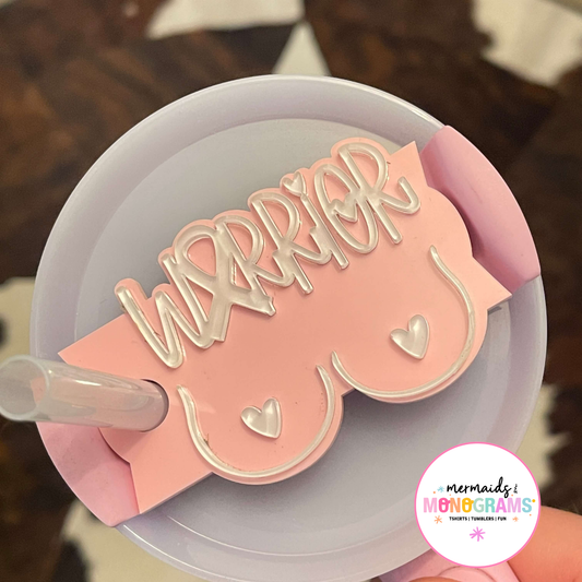 Close-up of pink acrylic “Warrior” topper on 40oz tumbler lid with heart details and awareness ribbon
